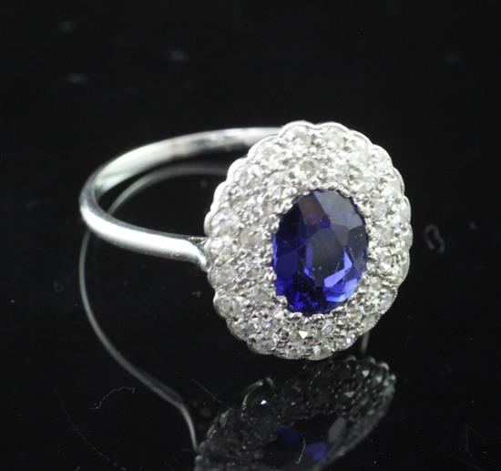 A 1930s/1940s platinum set diamond and synthetic sapphire oval cluster ring, size R.